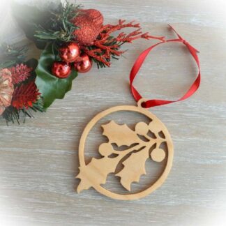 Round wooden Christmas decoration with holly sprig and red ribbon
