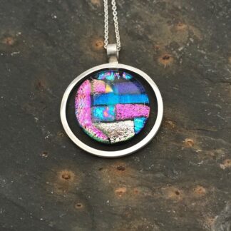 Mosaic dichroic glass circle within an eco-silver circle pendant.