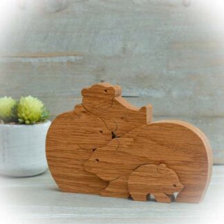Handcrafted Oak bear family of four nestling together