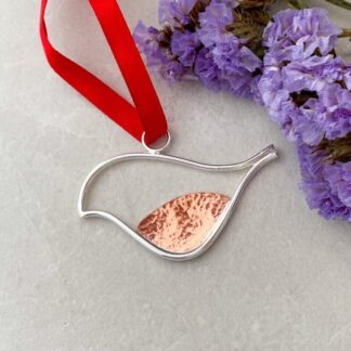 Silver and Copper robin decoration suspended from a red ribbon