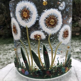 Fused glass dandelion heads and seed pods on a curved glass with a base