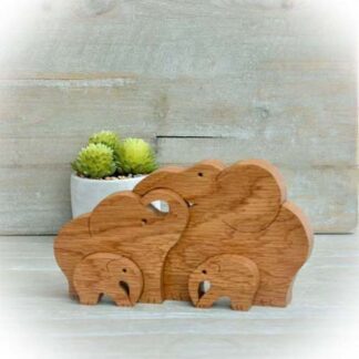 Handcrafted Oak elephant family of four nestling together