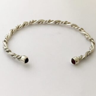 Twisted silver bangle with garnet ends