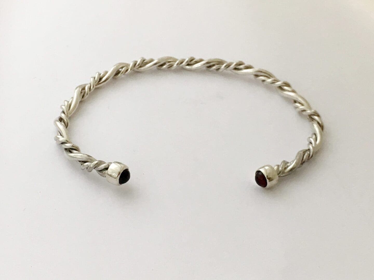 Twisted silver bangle with garnet ends