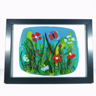 a fused glass floral scene in a picture frame