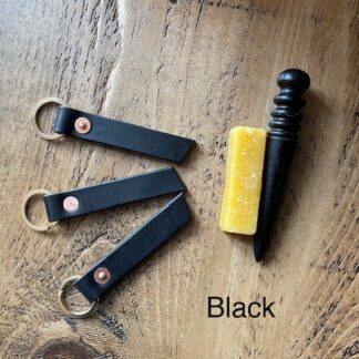 English veg tanned shoulder leather key fobs in black with brass split rings and copper saddlers rivets.