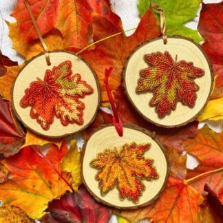 Hand Beaded autumn leaf artwork framed on a wooden slice with natural bark edging by DewCatDesigns