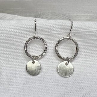 Sterling silver handmade earrings with a hammered hoop and satin finish circle