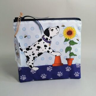 Medium flat toiletries bag with a pale blue back and featuring a spotty dog, bees and a sunflower in a pot on the front.