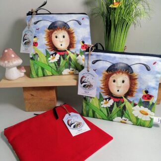Cotton toiletries bag featuring a character in a ladybug costume amongst the daisies. Bright red cotton back with a water resistant lining and internal pocket. Sealed by a chunky zipper. Great as a pencil case or overnight washbag