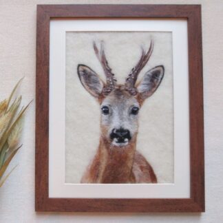 A needle felted wool picture of a roe deer buck in a dark wood effect frame.
