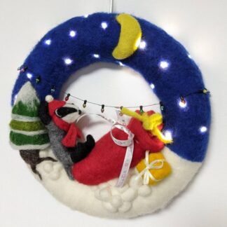 Beautiful badger indoor Christmas winter wreath. Battery lights. Postman badger under the stars in the snow.