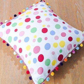 Bright spotty cushion cover with pom pom trim.