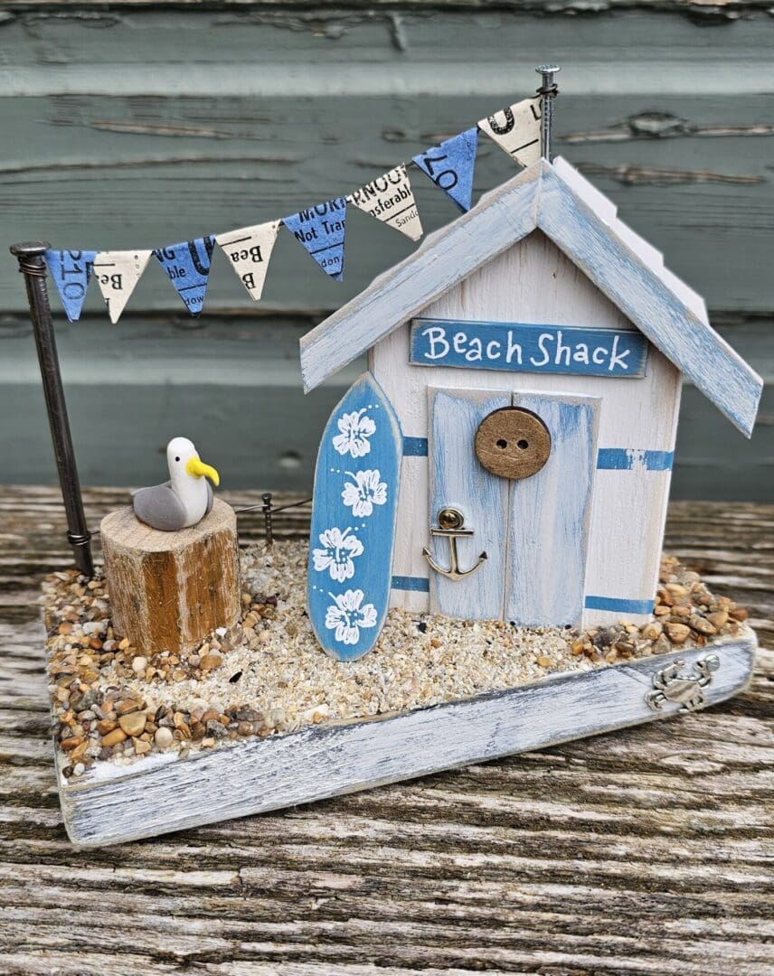 Weathered Beach Shack in Blue and White with Surfboard and Seagull - Image 6