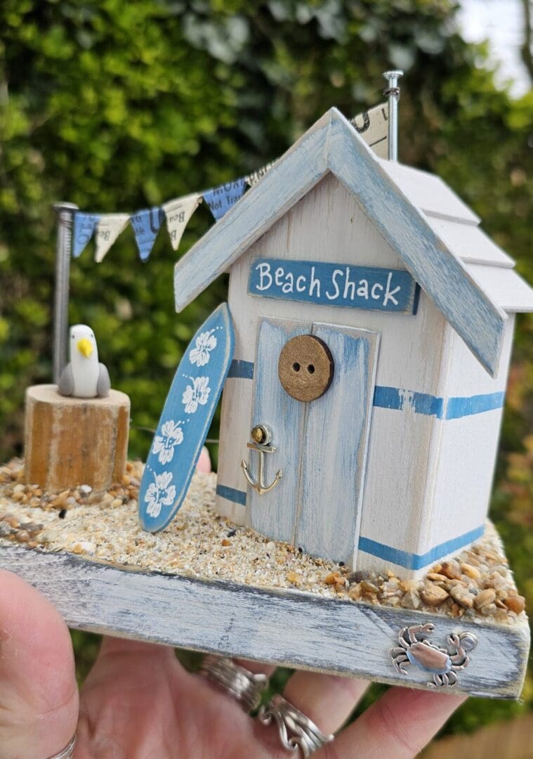 Weathered Beach Shack in Blue and White with Surfboard and Seagull - Image 5