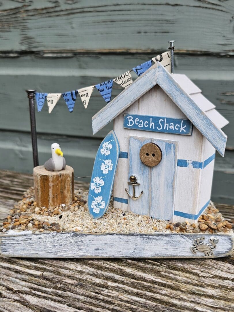 Weathered Beach Shack in Blue and White with Surfboard and Seagull - Image 3