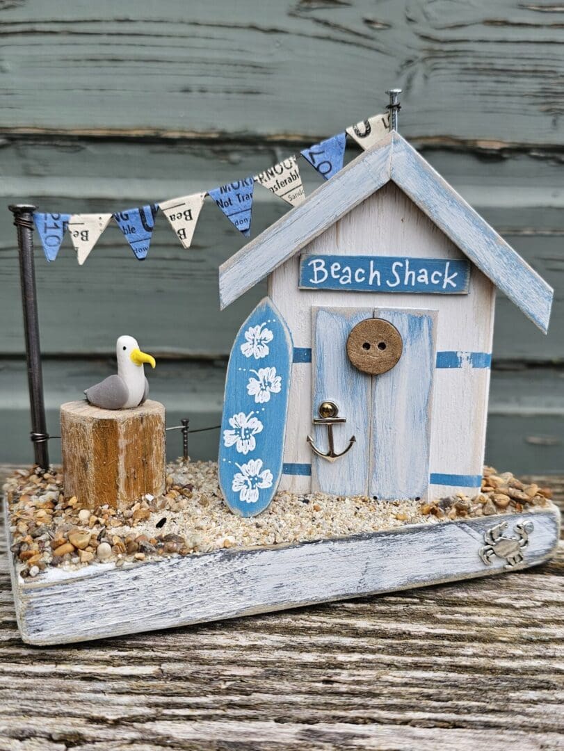 Weathered Beach Shack in Blue and White with Surfboard and Seagull - Image 2