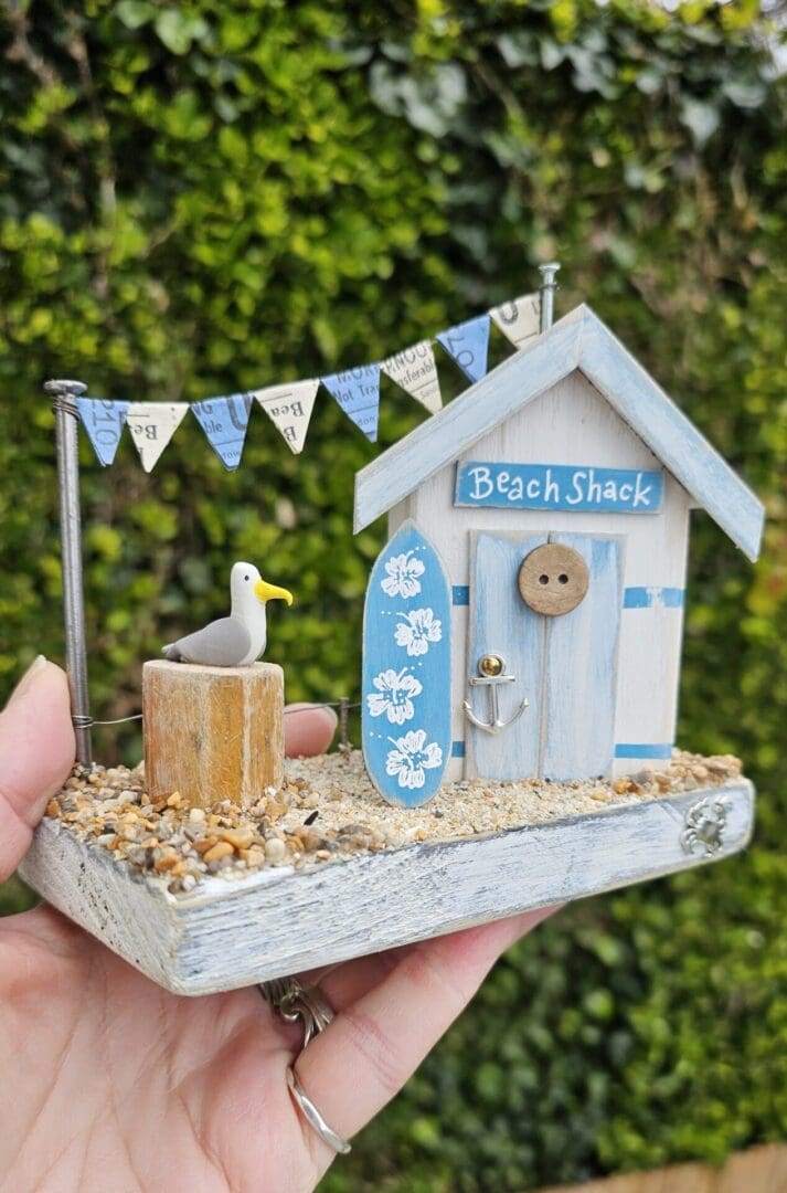 Weathered Beach Shack in Blue and White with Surfboard and Seagull