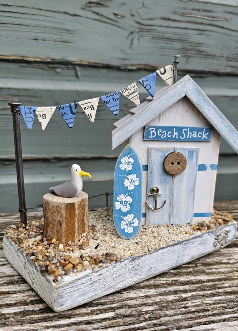 Weathered Beach Shack in Blue and White with Surfboard and Seagull - Image 4