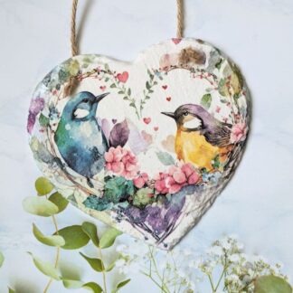 Slate hanging heart, painted white and decoupaged with colourful love birds inside a floral heart. Finished with a twine hanger.