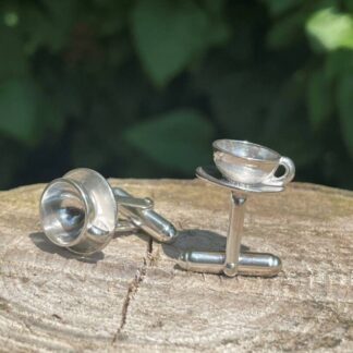 silver coffee cup cufflinks on wood base