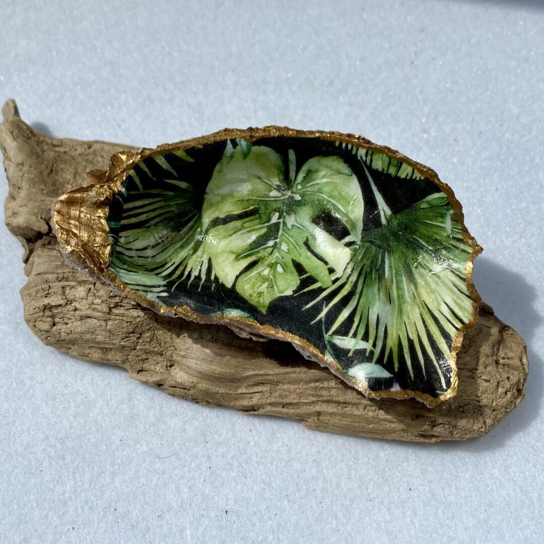 A stunning handcrafted Decoupaged Oyster Shell featuring dark jungle leaves