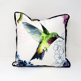 A printed velvet cushion with a bird motif and a purple velvet trim.