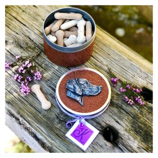 Circular Weimaraner dog treat tin with leatherette detail, and bone shaped treats inside. Dog portrait motif on the lid in cold-cast pewter.