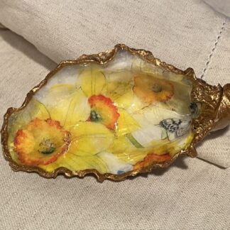 A handmade decoupaged oyster shell with spring daffodils