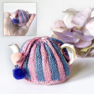 Collectible hand knitted traditional style miniature tea cosy on vintage miniature teapot.