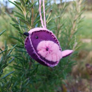 A handstitched felt and fabric bird in purple and pink