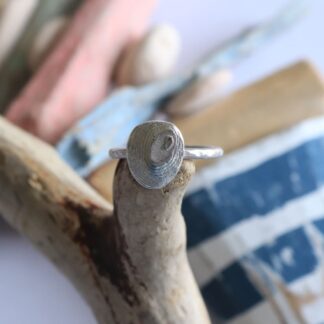 Silver hammered ring with setting textured with cuttlefish