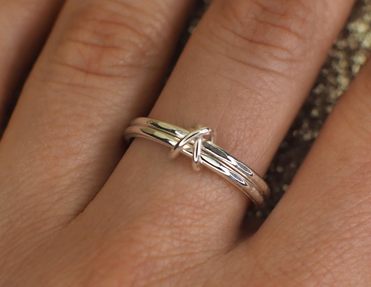 Double band fidget ring with cross bead on finger