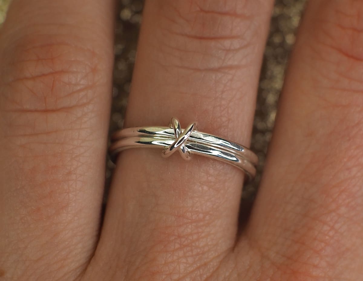 Double band fidget ring with cross bead on finger