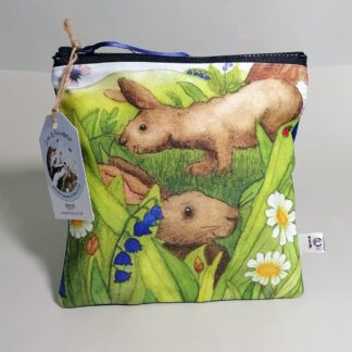 Square flat toiletries bag or roomy pencil case featuring two brown rabbits amongst the flowers and long grasses