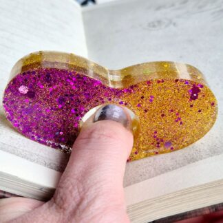 Pink gold resin page holder holding book pages open
