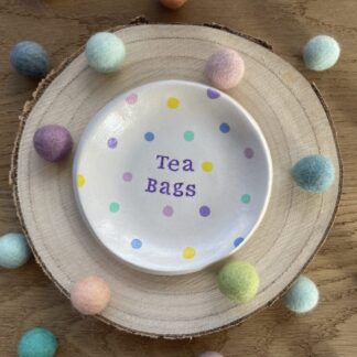 Multi coloured polka dot Tea Bag Dish surrounded by colourful felt balls