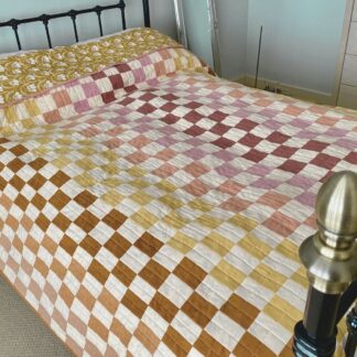 Double or king sized patchwork quilt in soft neutral cotton fabrics