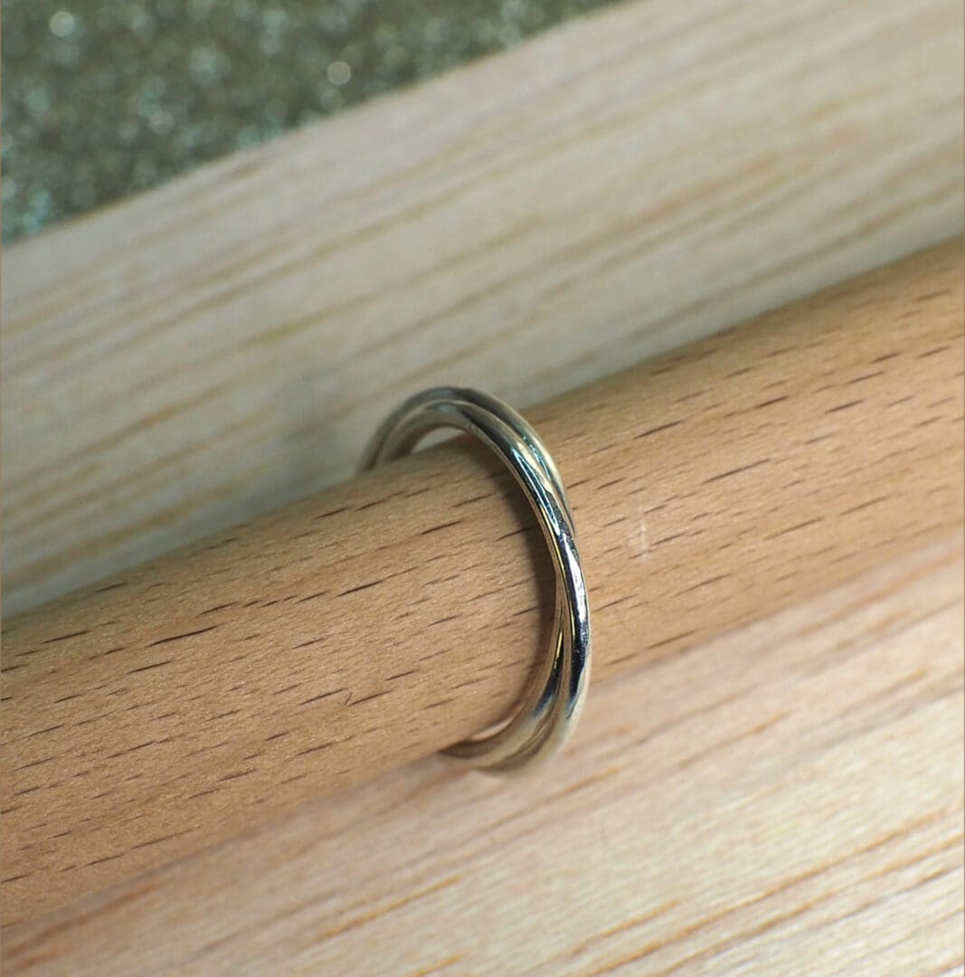 Sterling silver rolling ring shown closed on stand