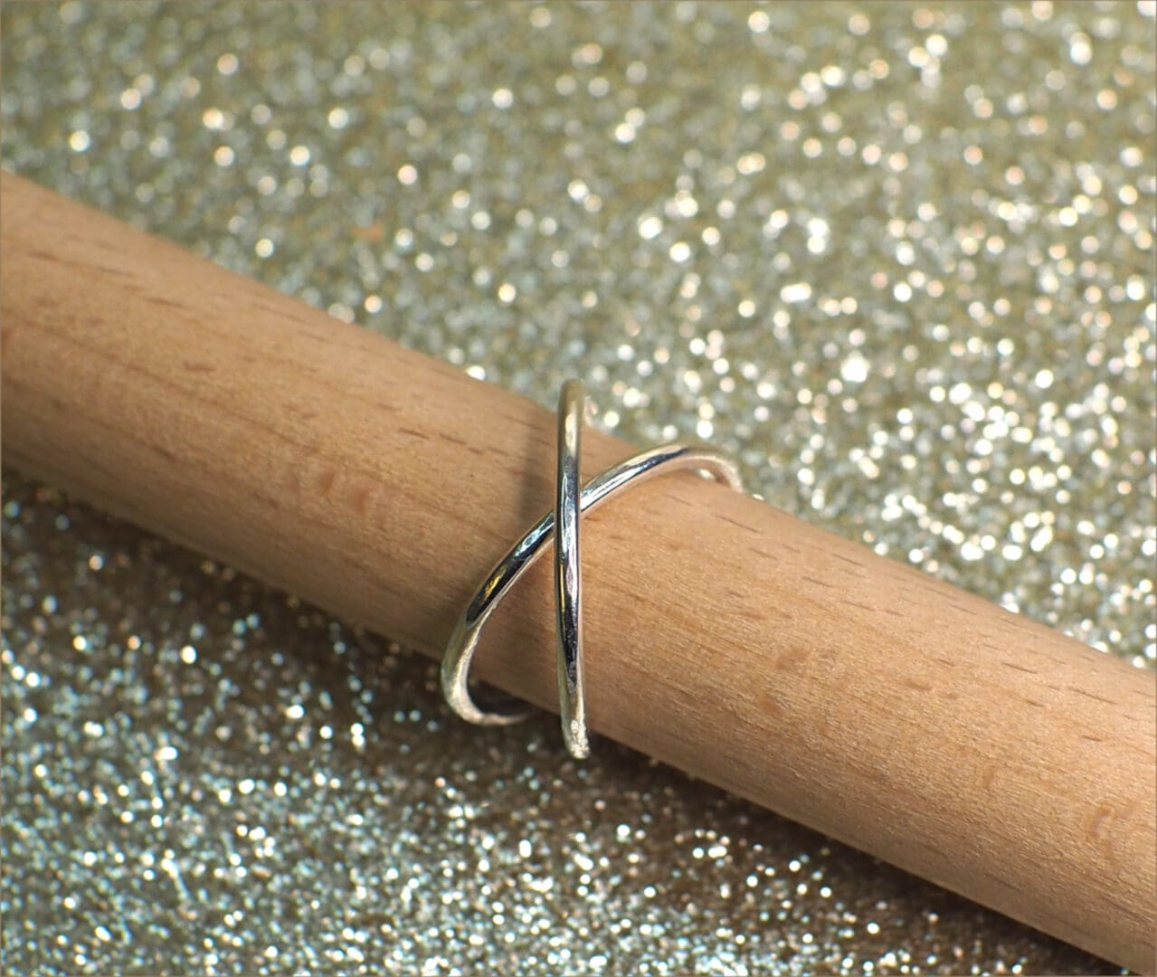 Sterling silver rolling ring shown on stand