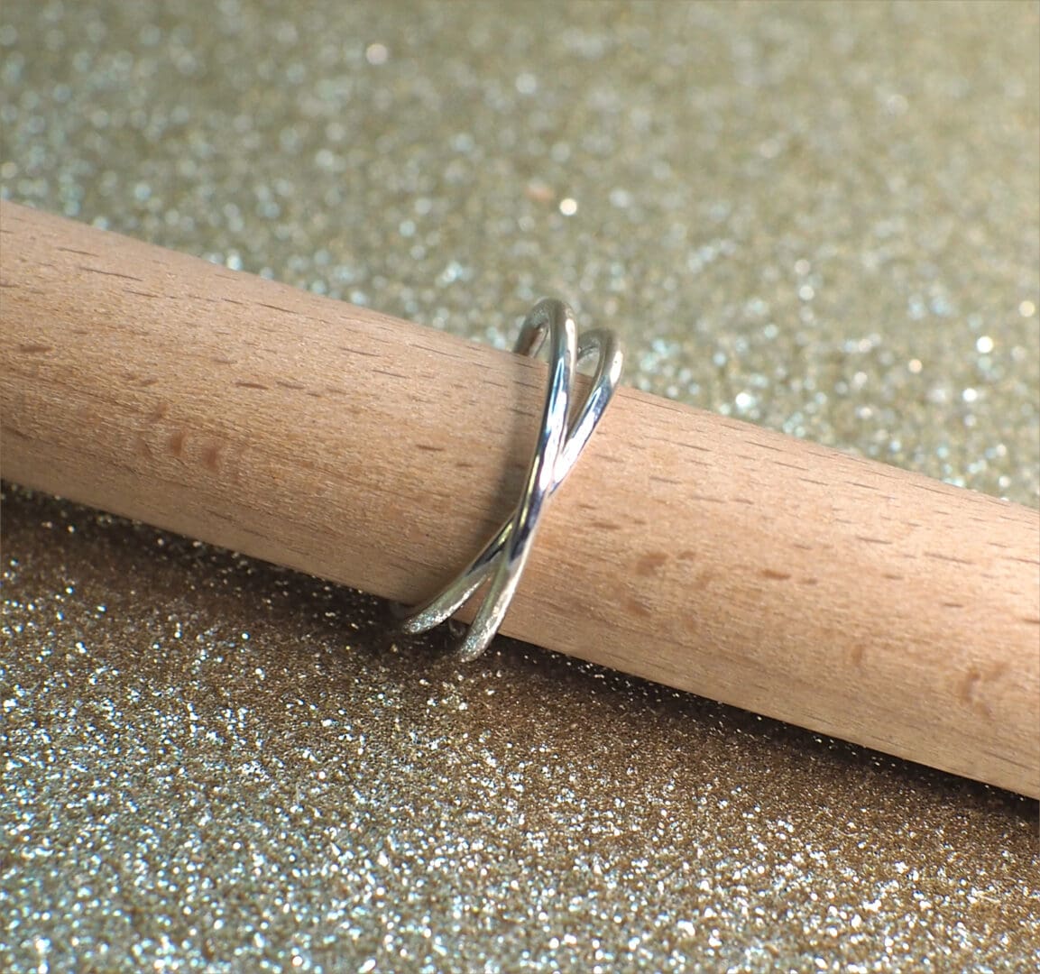 Sterling silver rolling ring shown on stand