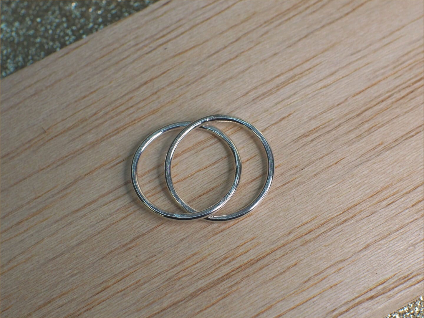 Sterling silver rolling ring shown linked on table