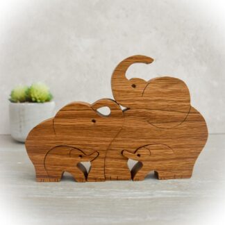 Handcrafted oak elephant family of four with trunks raised for good luck