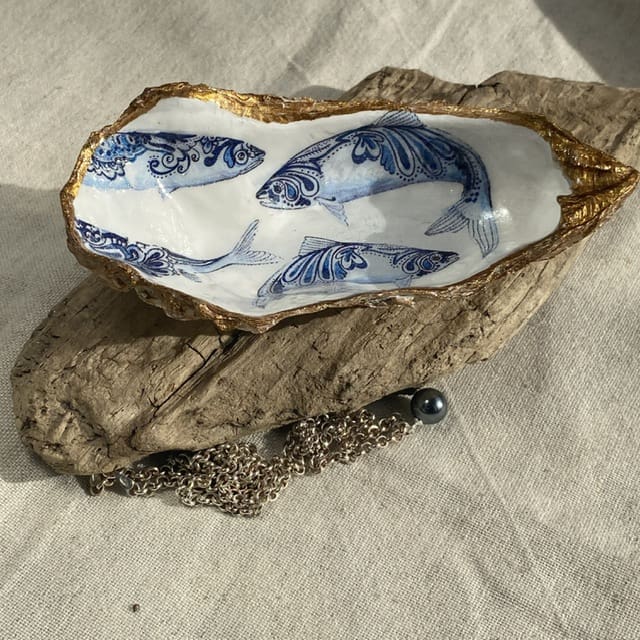 A handmade decoupaged oyster featuring lovely pretty blue fish.