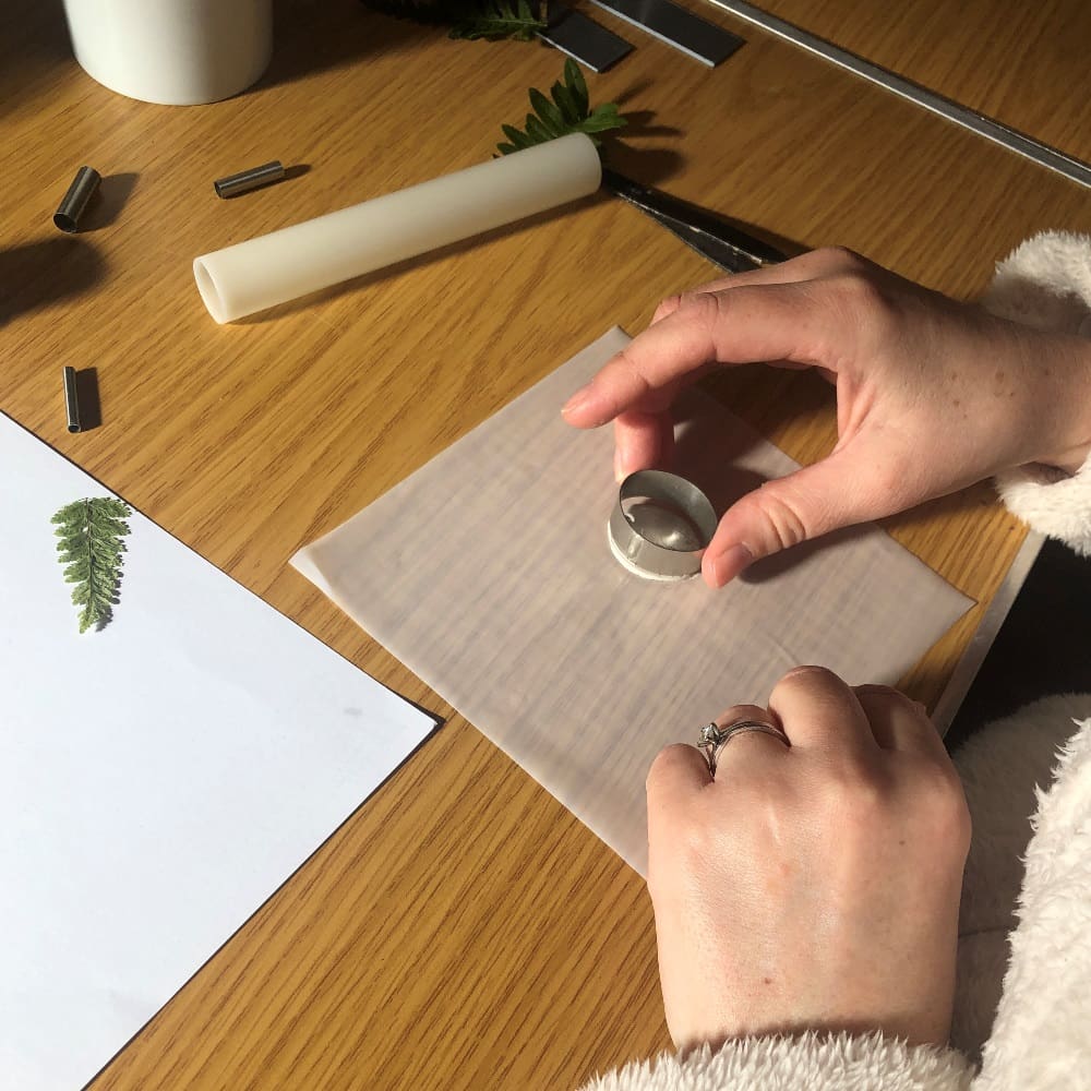 A workshop participant cutting an oval shape from silver metal clay on the Silver Metal Clay Beginners Jewellery Workshop