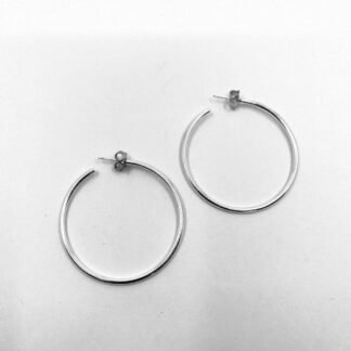 Sterling silver hoop earrings on a white background. The earrings have post and scroll fittings for the earlobe.