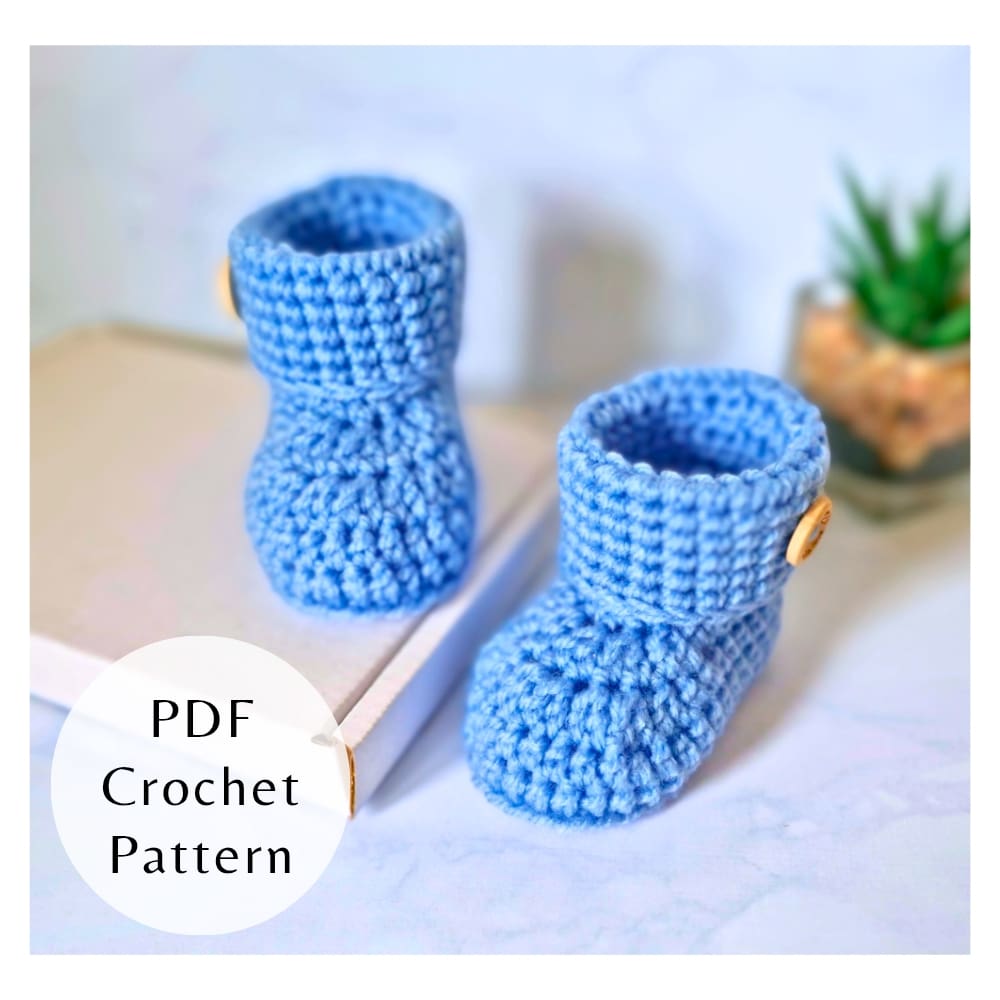 A digital PDF crochet pattern for baby button booties displayed in blue with wooden buttons.