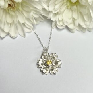 Handmade silver daisy flower necklace with intricate detail and set with yellow cubic zirconia