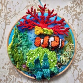 A stumpwork weaved Clown fish mounted on a 7” Embroidery Hoop