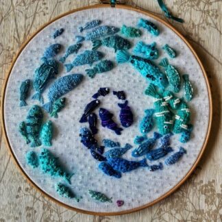 10" Embroidery Hoop with 49 different fish in shades of blue swimming in a swirl